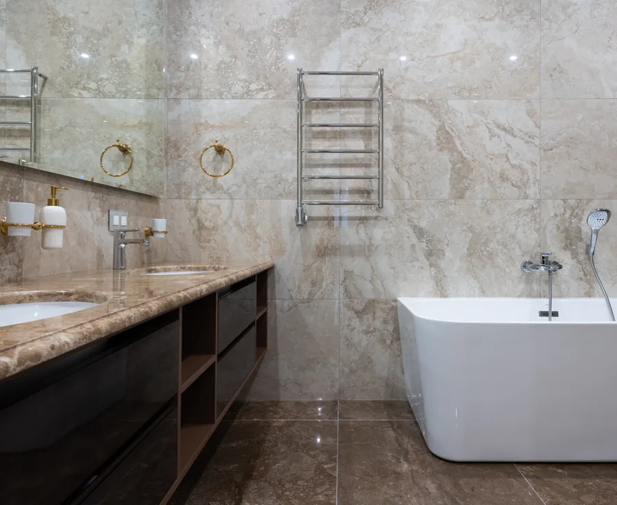 Salle de bain en marbre beige et brun, double vasque encastrée et baignoire blanche