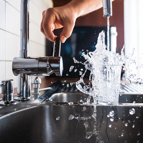Verre rempli sous un mitigeur d'évier