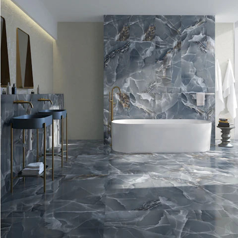 Mur et sol en grandes dalles de marbre bleu gris derrière une baignoire îlot