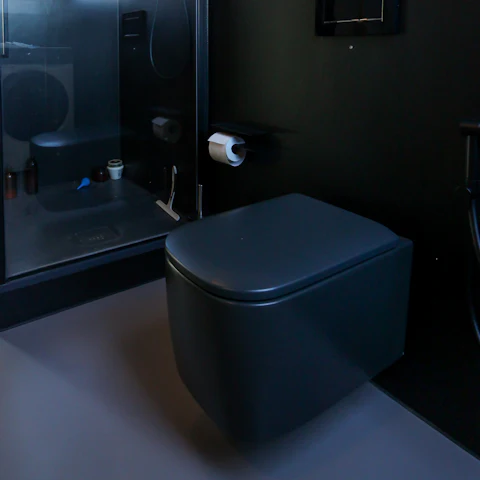 WC suspendu en céramique noire mate, dans une salle de bain sombre